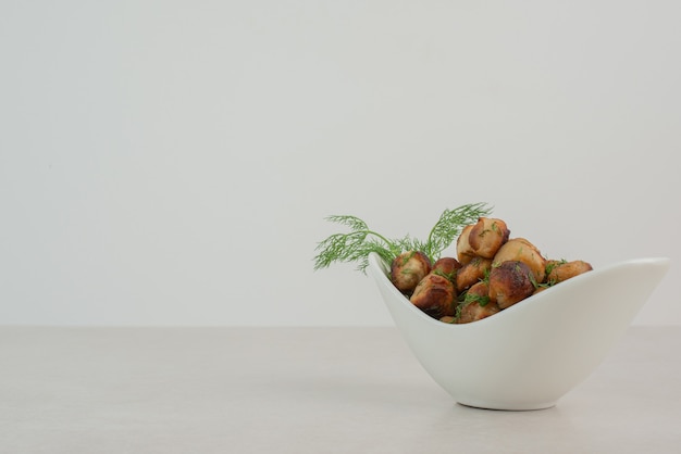 Fried potato with greens on white plate .