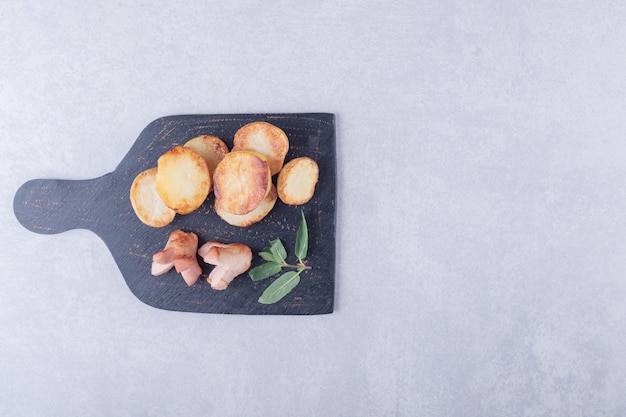 Patate fritte e salsicce sul bordo nero.