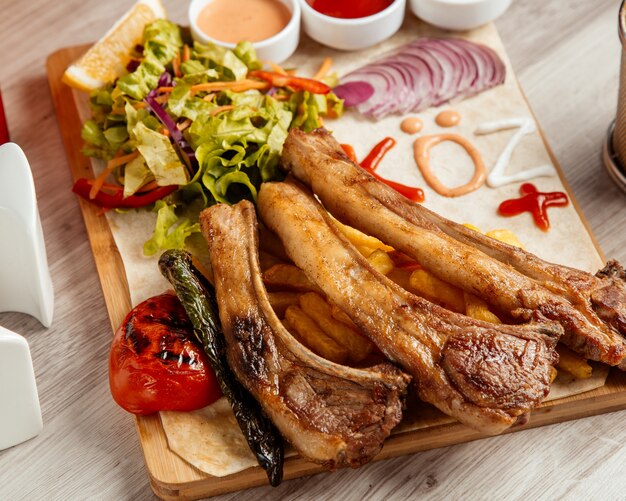 Fried ribs  french fries  tomato  green salad  side view