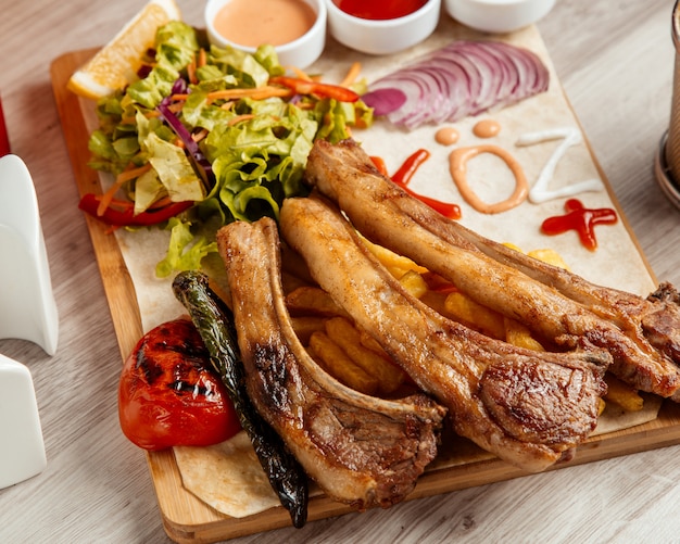 Fried ribs  french fries  tomato  green salad  side view