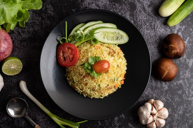 Fried rice with minced pork, tomato, carrot and cucumber on the plate