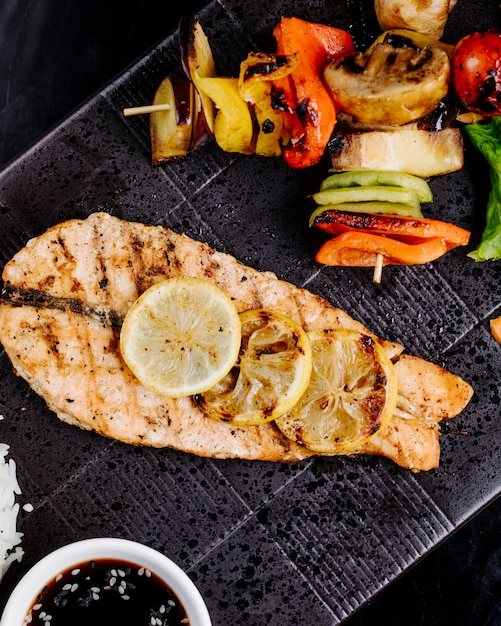 Free photo fried salmon steak with lemon slices on top