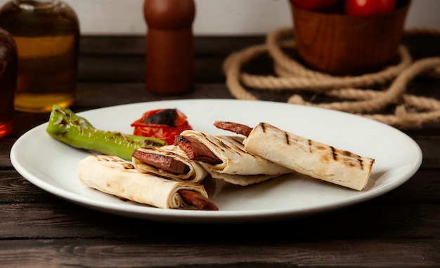 Free photo fried sausage in pita bread on a wooden table