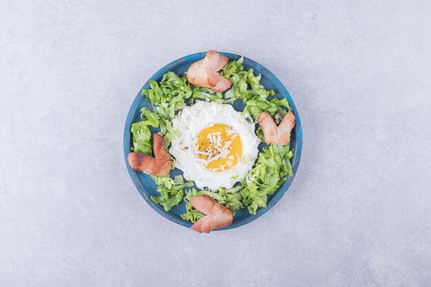 Fried sausages and egg on blue plate. 