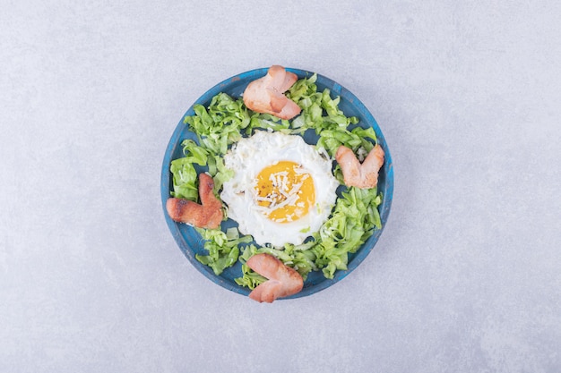 Fried sausages and egg on blue plate. 