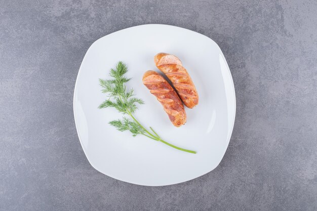 Fried sausages in a white plate