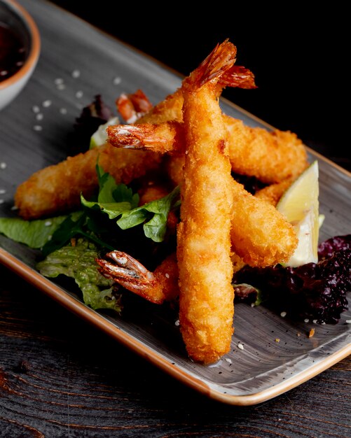 fried shrimps served with lemon slices lettuce and sauce