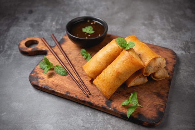 Fried spring rolls on cutting board.