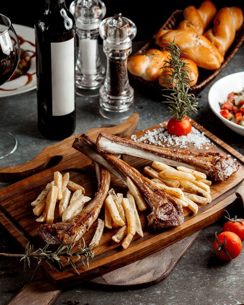 Fried steak with french fries on wooden board