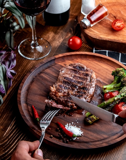 Fried steak on wooden board top view