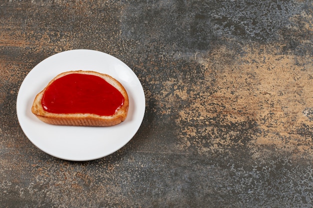 Free photo fried toast with strawberry jam on white plate.