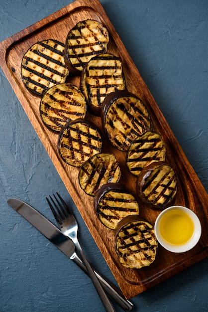 Fried vegetable eggplants with oil on wooden board.