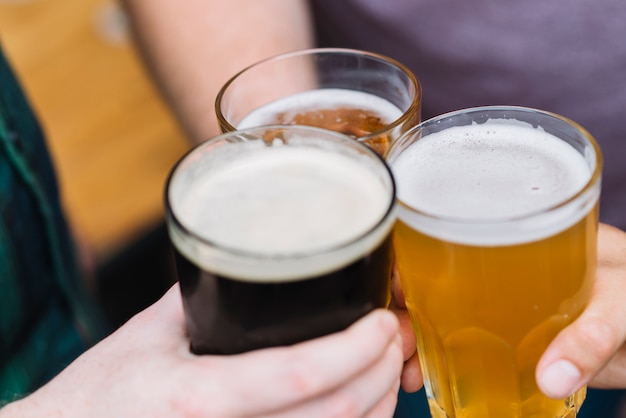 Free photo friend's hand toasting glass of alcoholic drinks