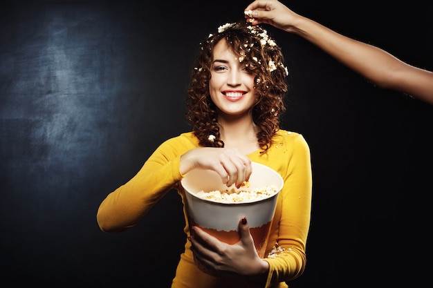 Friend thowing popcorn on beautiful woman while watching interesting film