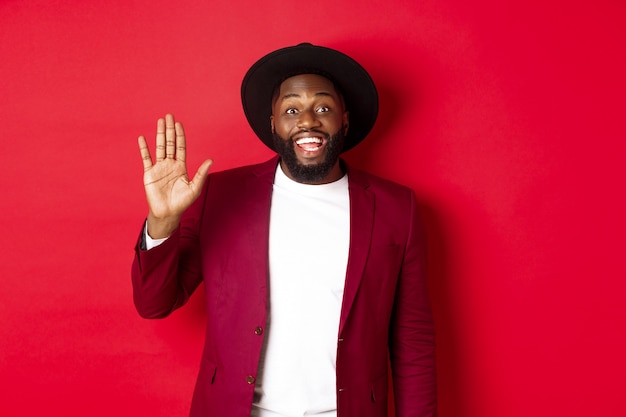 Friendly african american guy waving hand