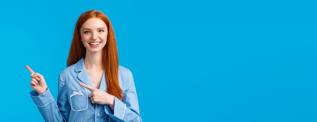 Friendly attractive redhead female student showing person way in dormitory college pointing right an