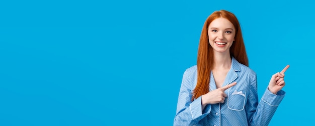 Friendly attractive redhead female student showing person way in dormitory college pointing right an