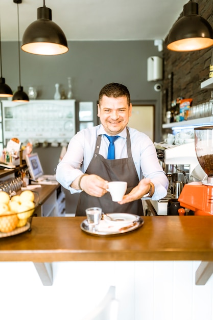 Foto gratuita barman amichevole con caffè