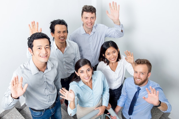 Friendly Business Team Waving on Office Stairway