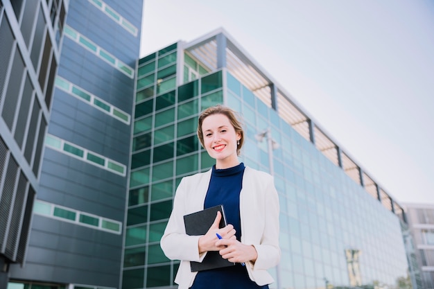 Friendly businesswoman holding book