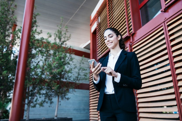 Foto gratuita amichevole donna d'affari con smartphone