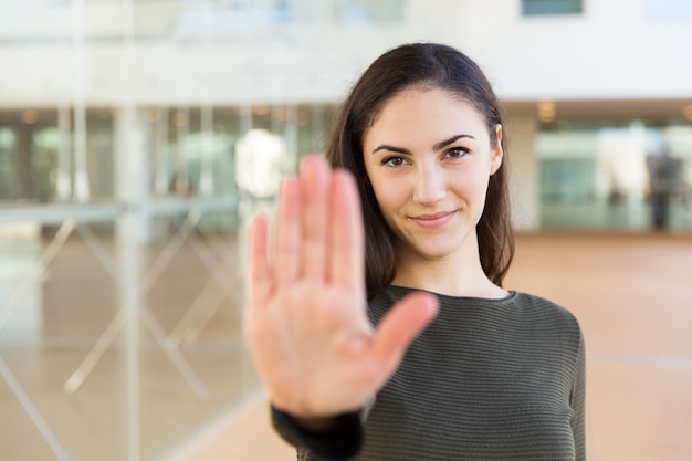 Friendly confident beautiful woman making hand stop gesture