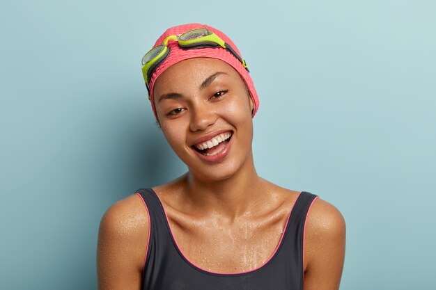 Friendly female swimmer posing with goggles