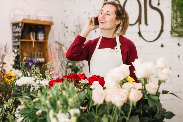 Friendly florist speaking on smartphone