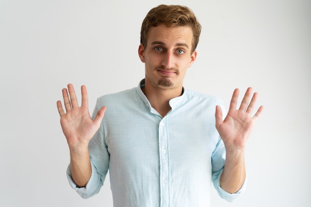 Дружелюбный парень в белой повседневной рубашке gesturing Fine, You Won.
