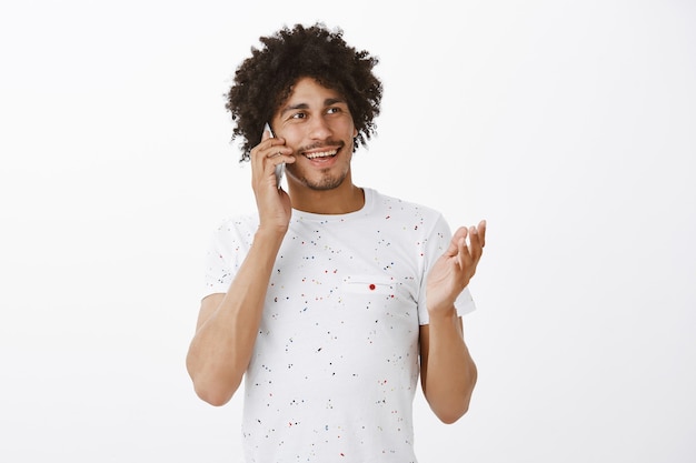 Friendly handsome man talking on mobile phone, smiling happy