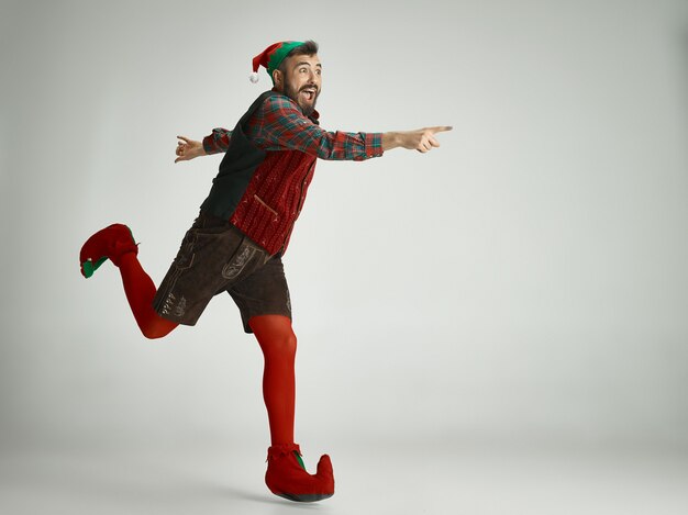 friendly man dressed like a funny gnome posing on an isolated gray