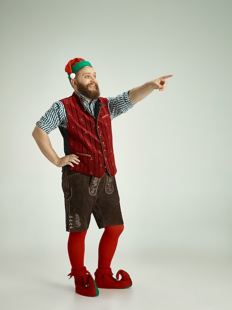 friendly man dressed like a funny gnome posing on an isolated gray