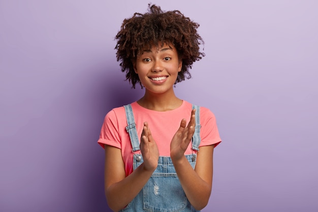 Friendly positive female claps hands, applauds friend or colleague who achieved great success