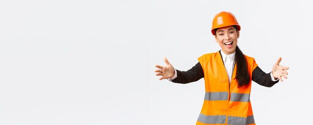 Дружелюбная улыбающаяся азиатская женщина-строитель, инженер в защитном шлеме и светоотражающей куртке e