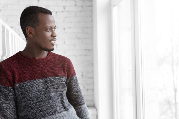 Friendly and smiling young African man enjoying beautiful urban view outside