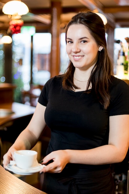 Free photo friendly waitress with cup of hot drink
