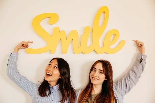 Friendly women pointing at smile writing