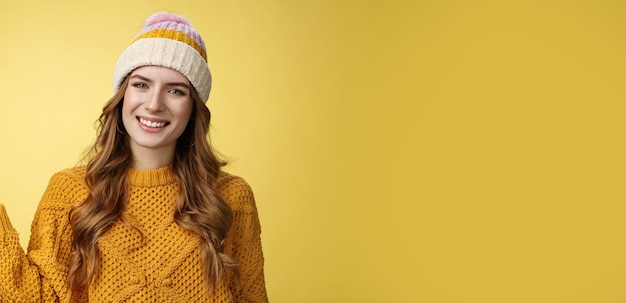 Free photo friendlylooking confident pleasant attactive young european woman wearing winter hat sweater extend