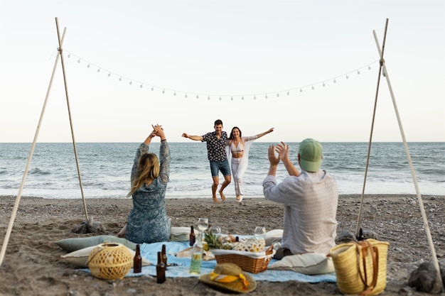 Friends at the beach dancing together during party