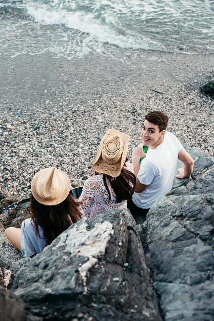 Friends at the beach next to rocks