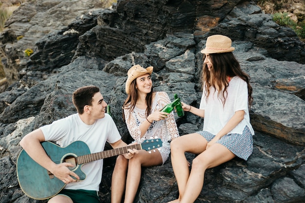 Friends at the beach with guitar and beer