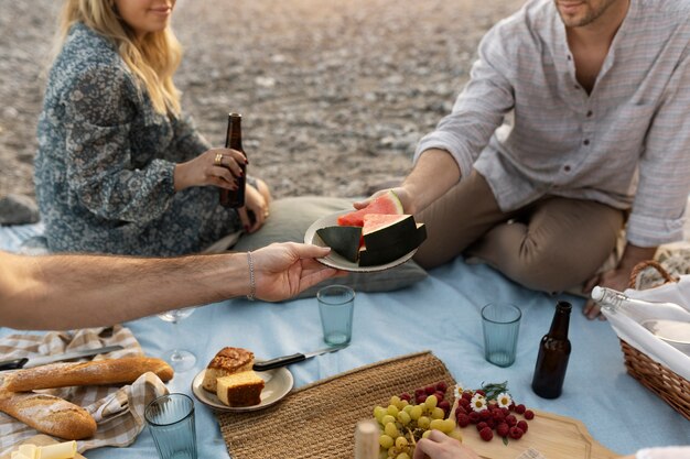 Friends at the beach with watermelon and beer