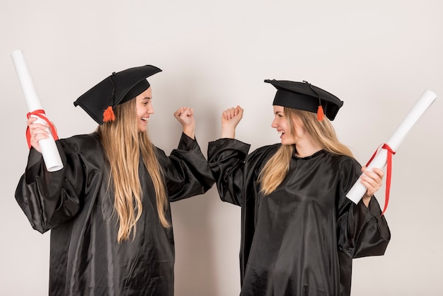 Friends being cheerful at graduation ceremony