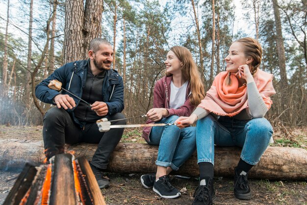 Friends at bonfire cooking marshmallow