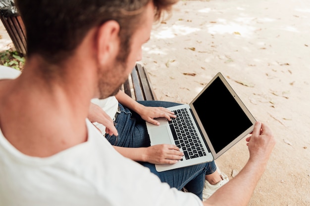 Friends browsing on a laptop outdoor