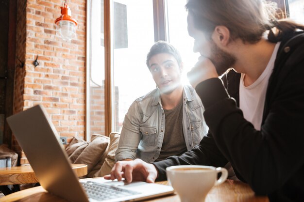 Friends by the table with laptop