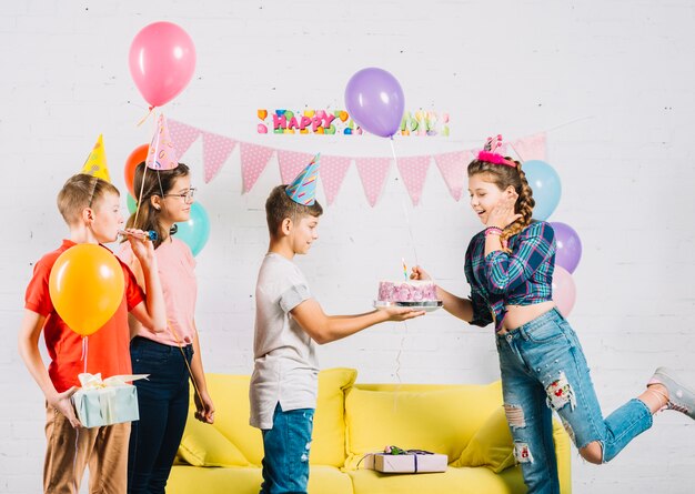 Friends celebrating girl's birthday with cake