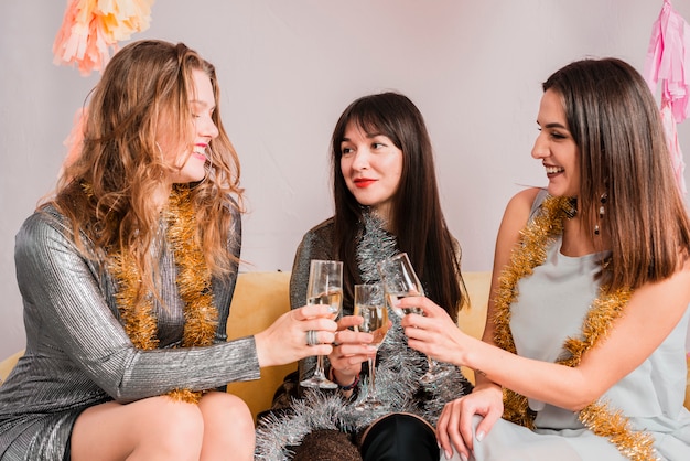 Free photo friends chatting on a sofa at a new year party