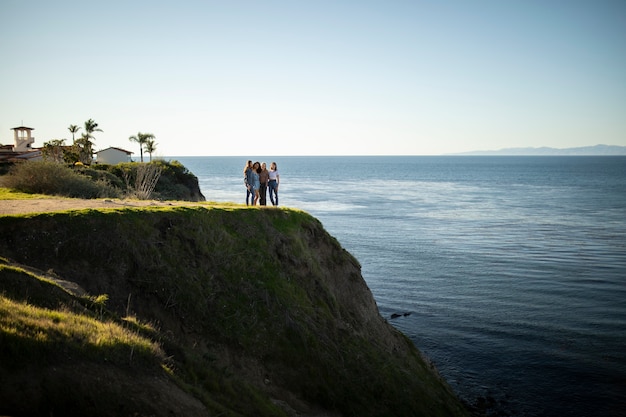 Friends on coast looking at ocean long shot