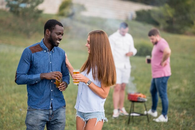 バーベキューでビールを飲みながら会話する友達